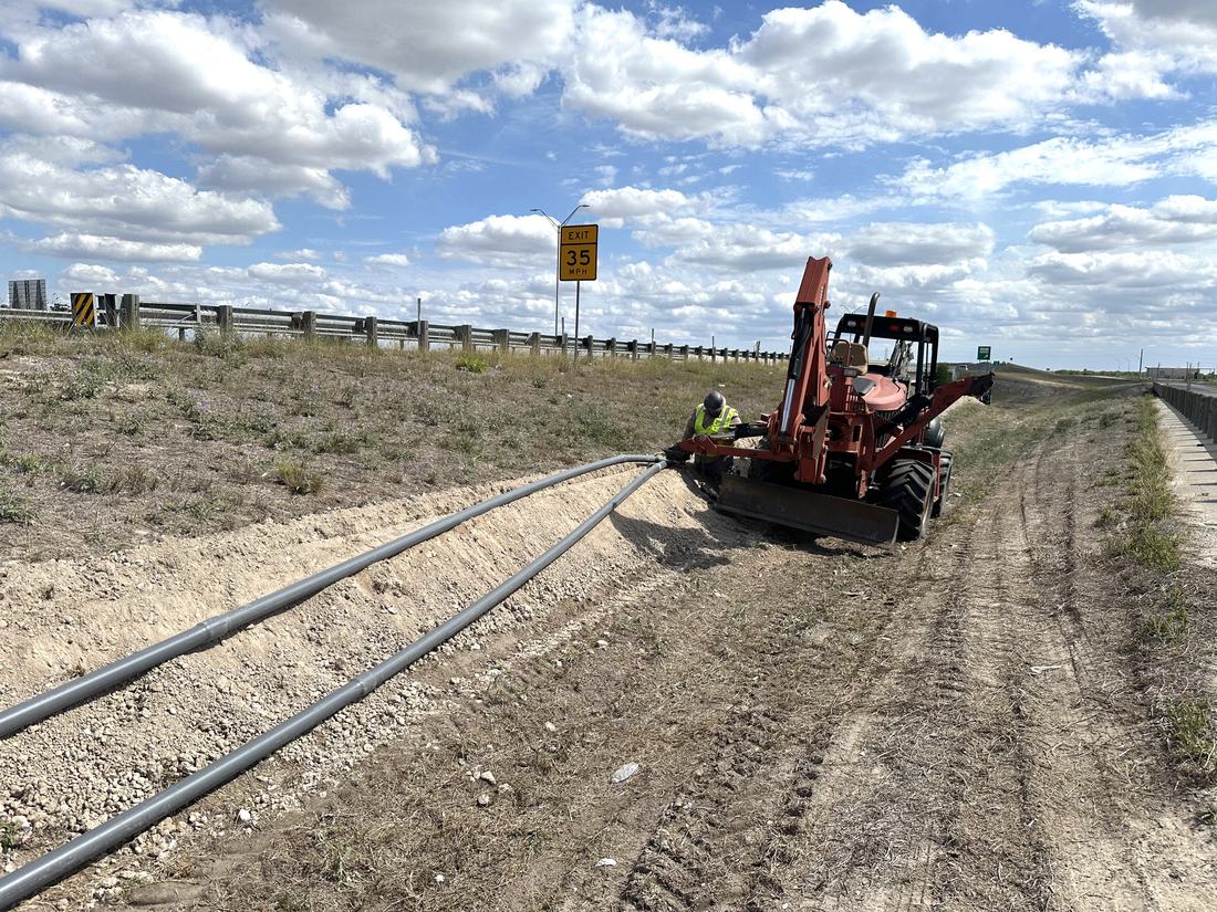 Trenching conduit along the freeway